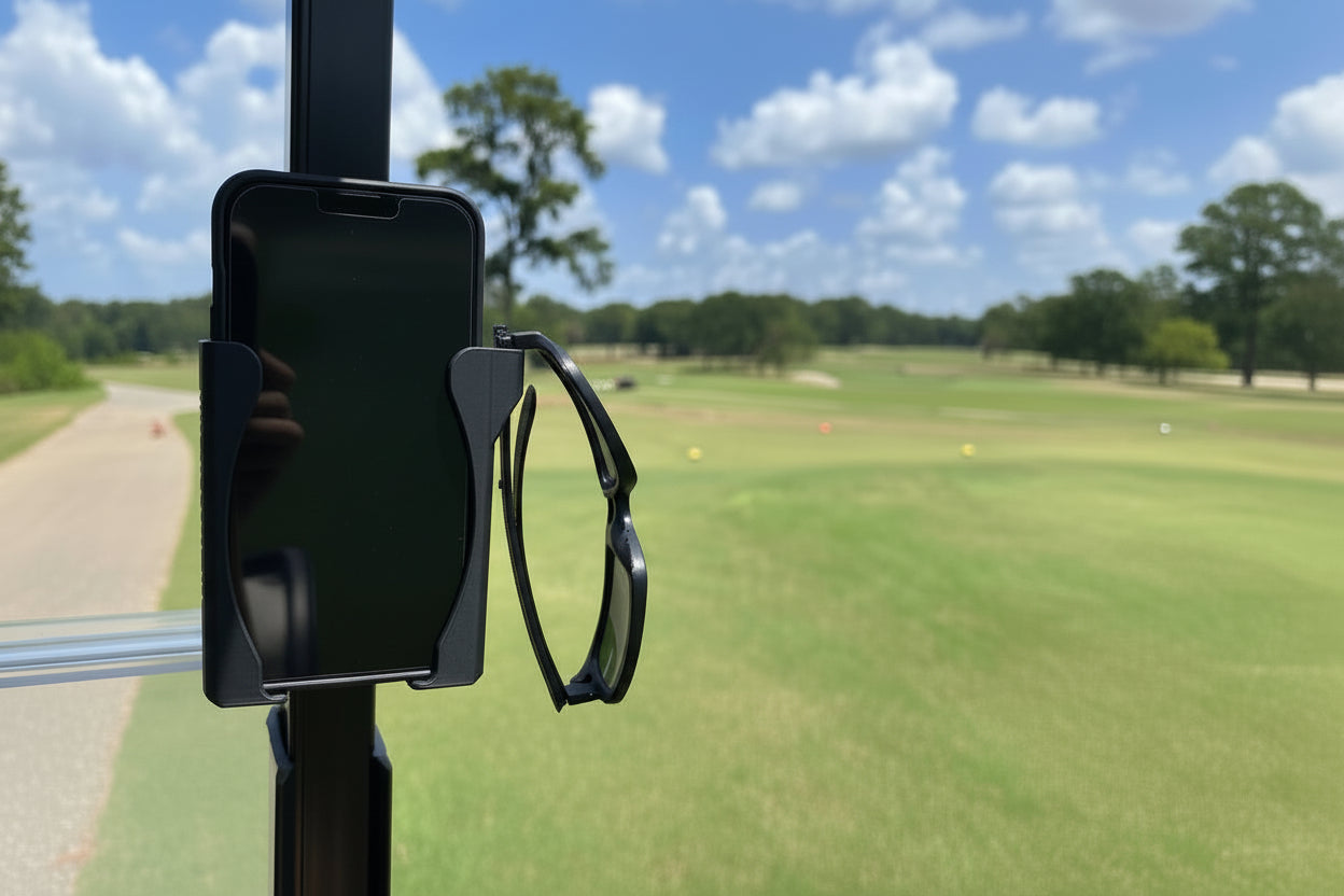 Phone holder with sunglasses on a golf cart against a golf course background